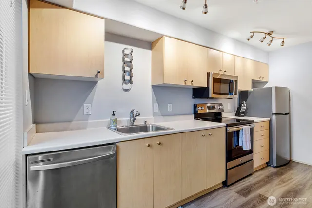 a kitchen with stainless steel appliances a sink stove and microwave
