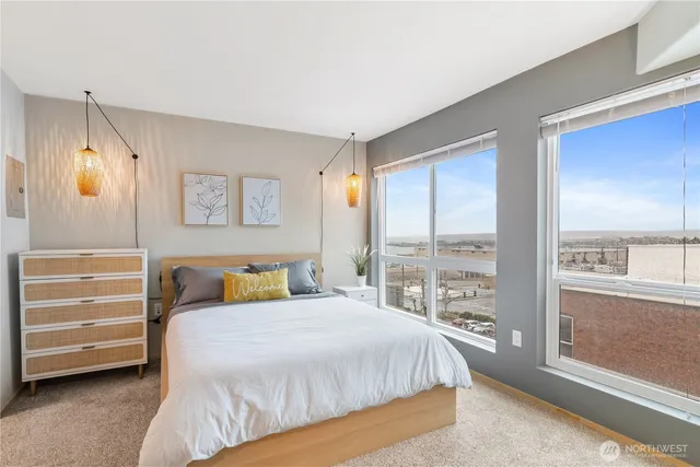 a bedroom with a bed a large window with outer view