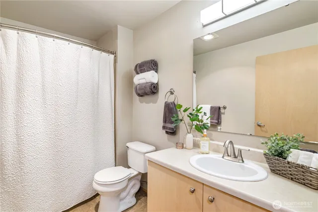 a bathroom with a granite countertop sink mirror vanity and toilet