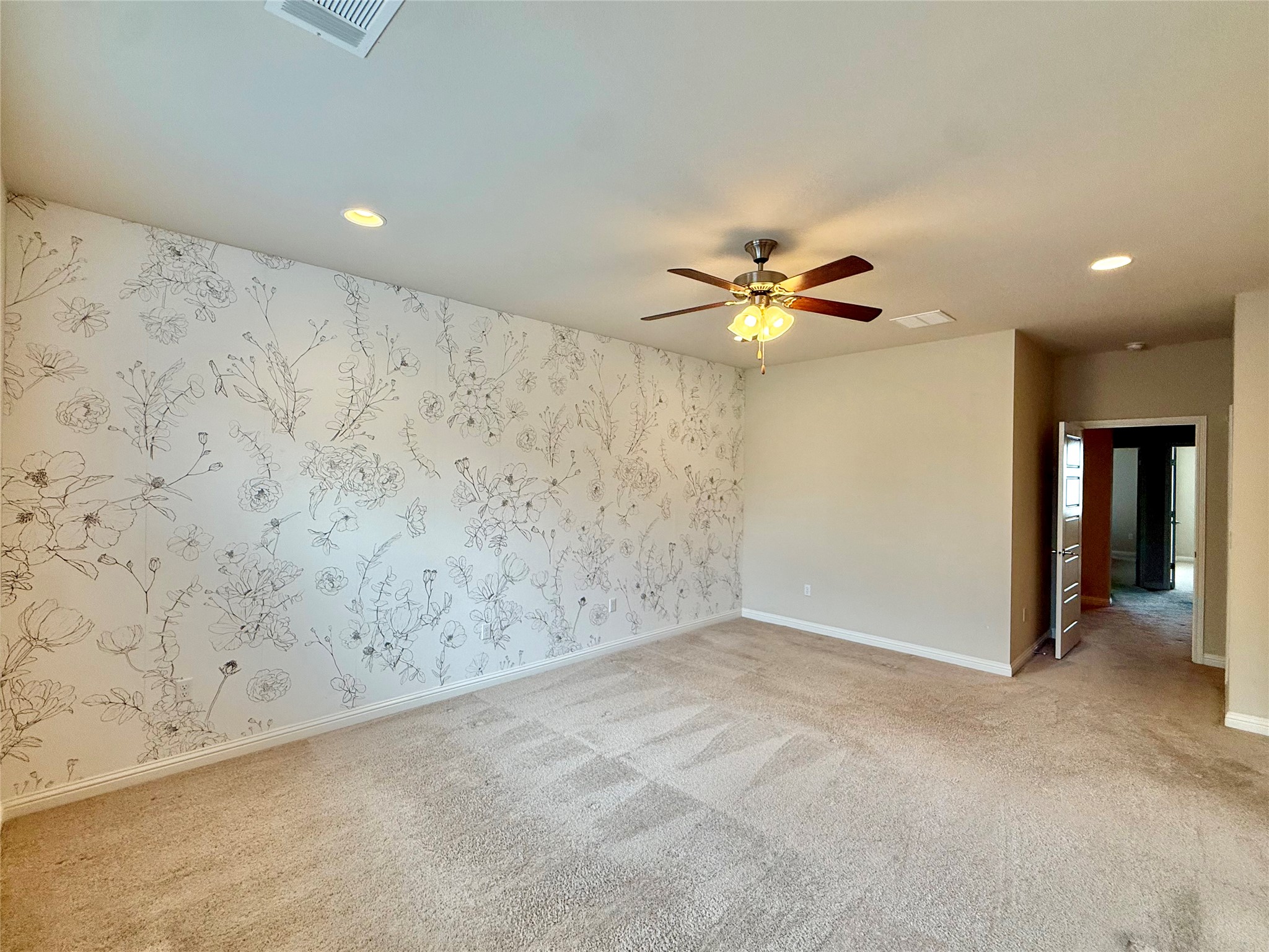 6814 East Riverside Drive, Unit 73 Austin, TX 78741 - Photo 16 of 33 Spacious room featuring an accent wall with botanical-patterned wallpaper, neutral carpeting, a ceiling fan with integrated lighting, recessed lighting, and white baseboards