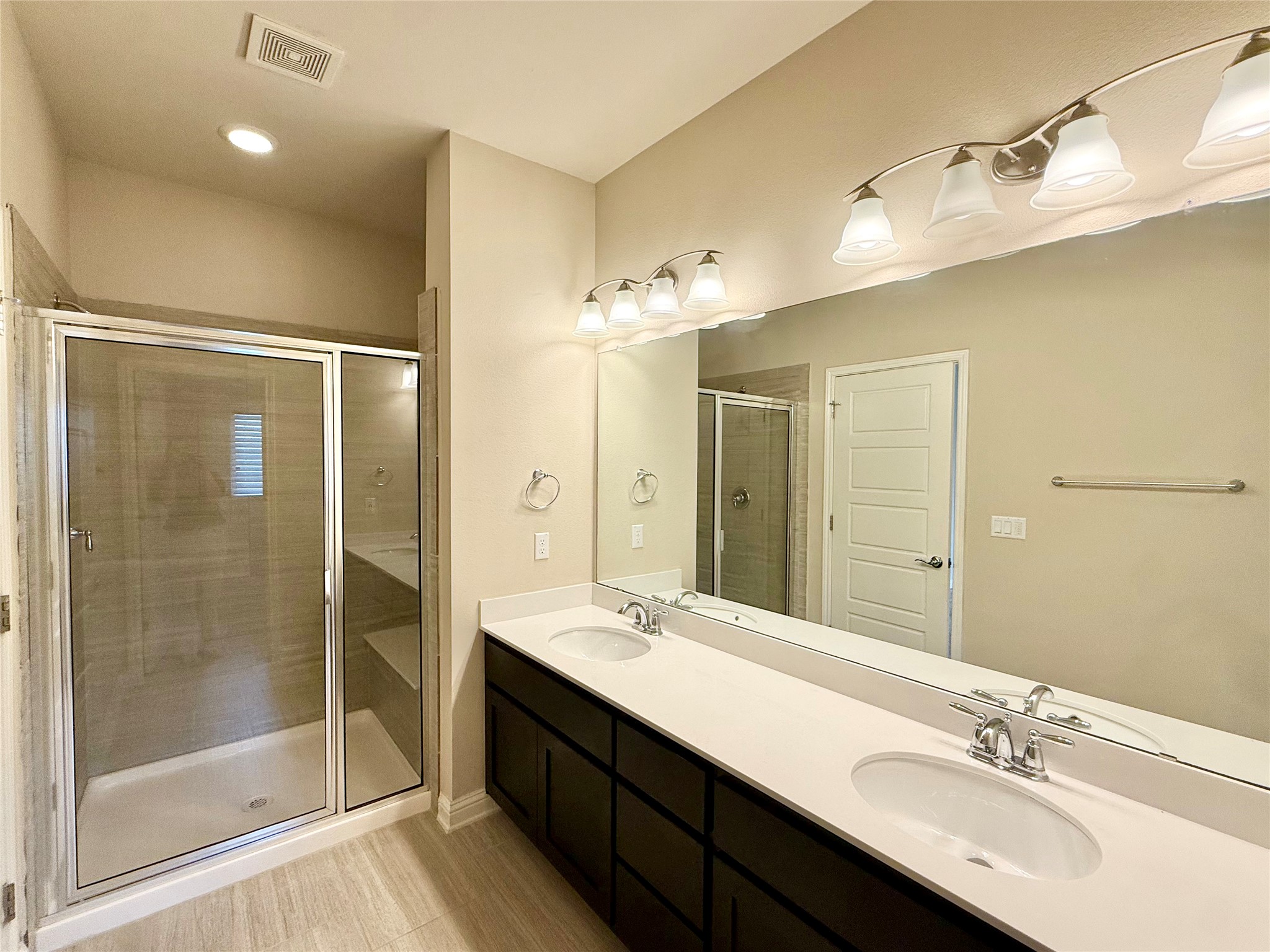 6814 East Riverside Drive, Unit 73 Austin, TX 78741 - Photo 17 of 33 Spacious bathroom featuring a dual vanity with white countertops, dark wood cabinetry, and chrome fixtures