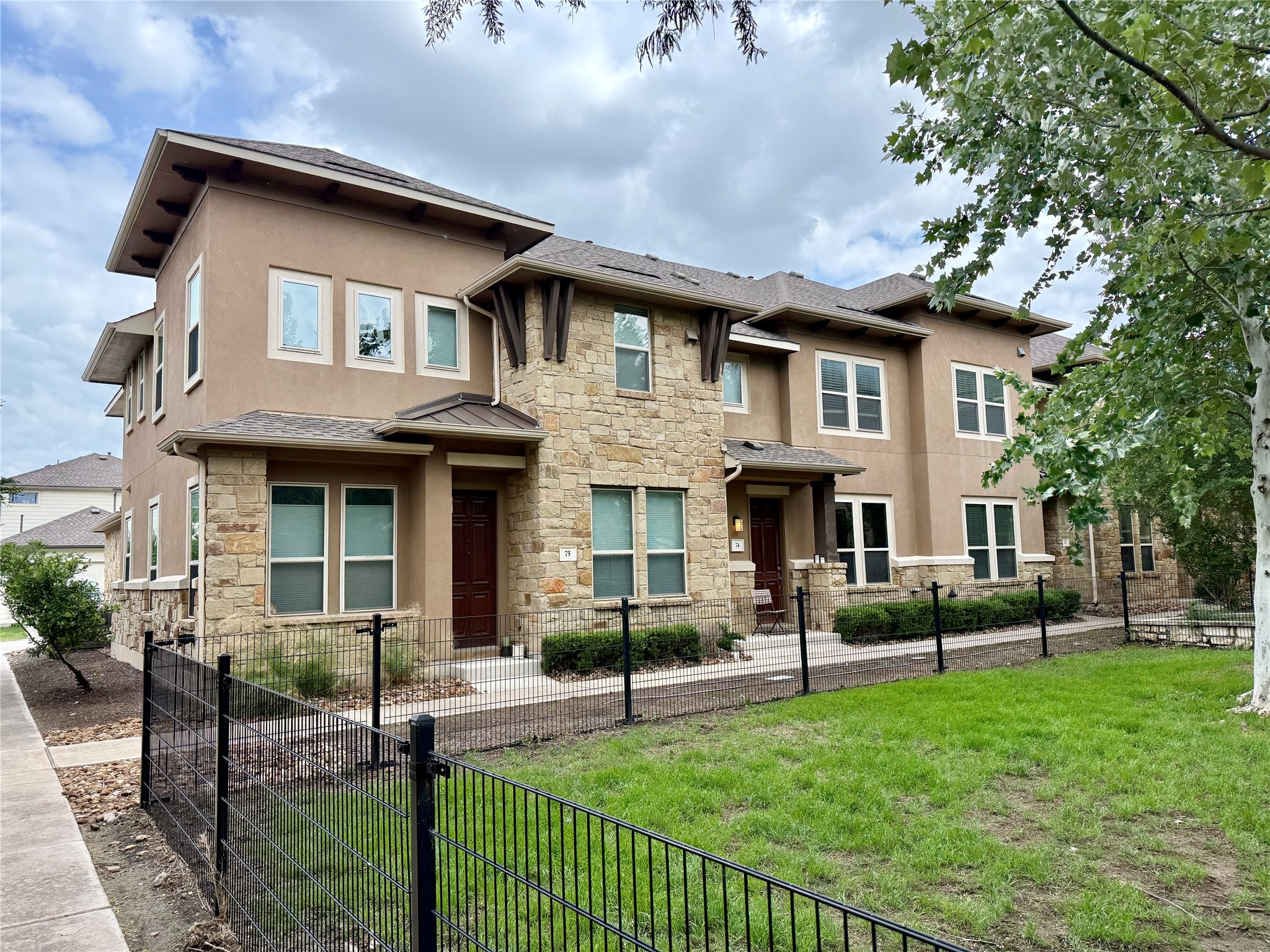 6814 East Riverside Drive, Unit 73 Austin, TX 78741 - Photo 2 of 33 Modern stucco and stone facade featuring multiple windows