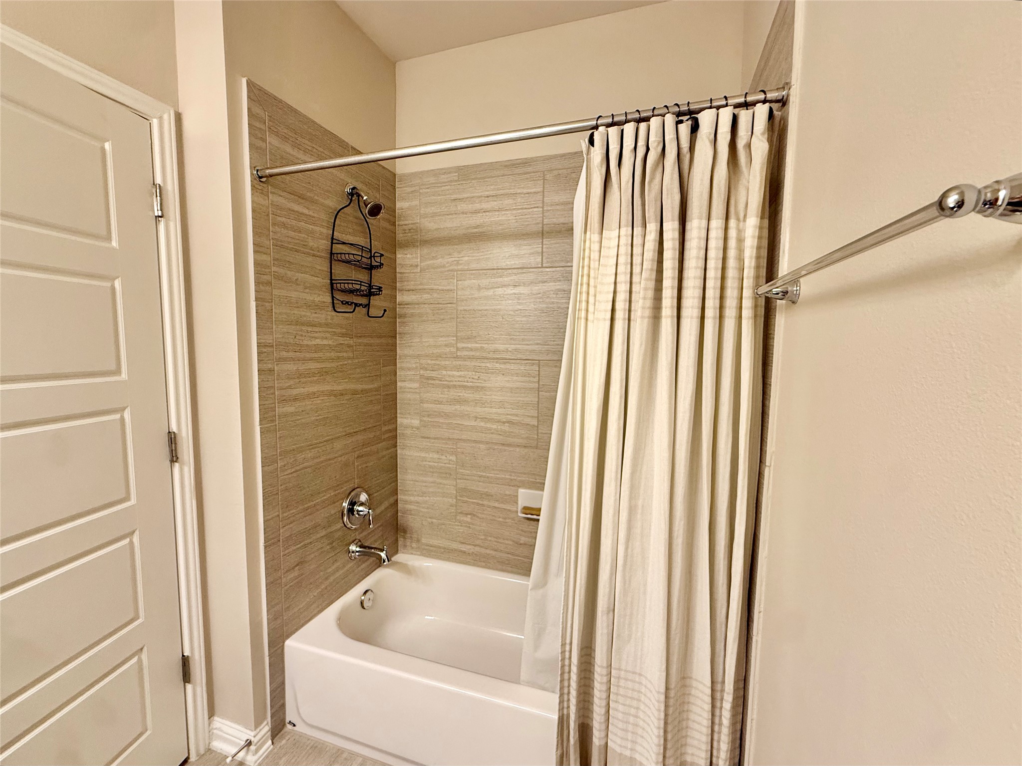 6814 East Riverside Drive, Unit 73 Austin, TX 78741 - Photo 22 of 33 Bathroom featuring a white tub with chrome fixtures, an integrated shower head, and tiled shower surround