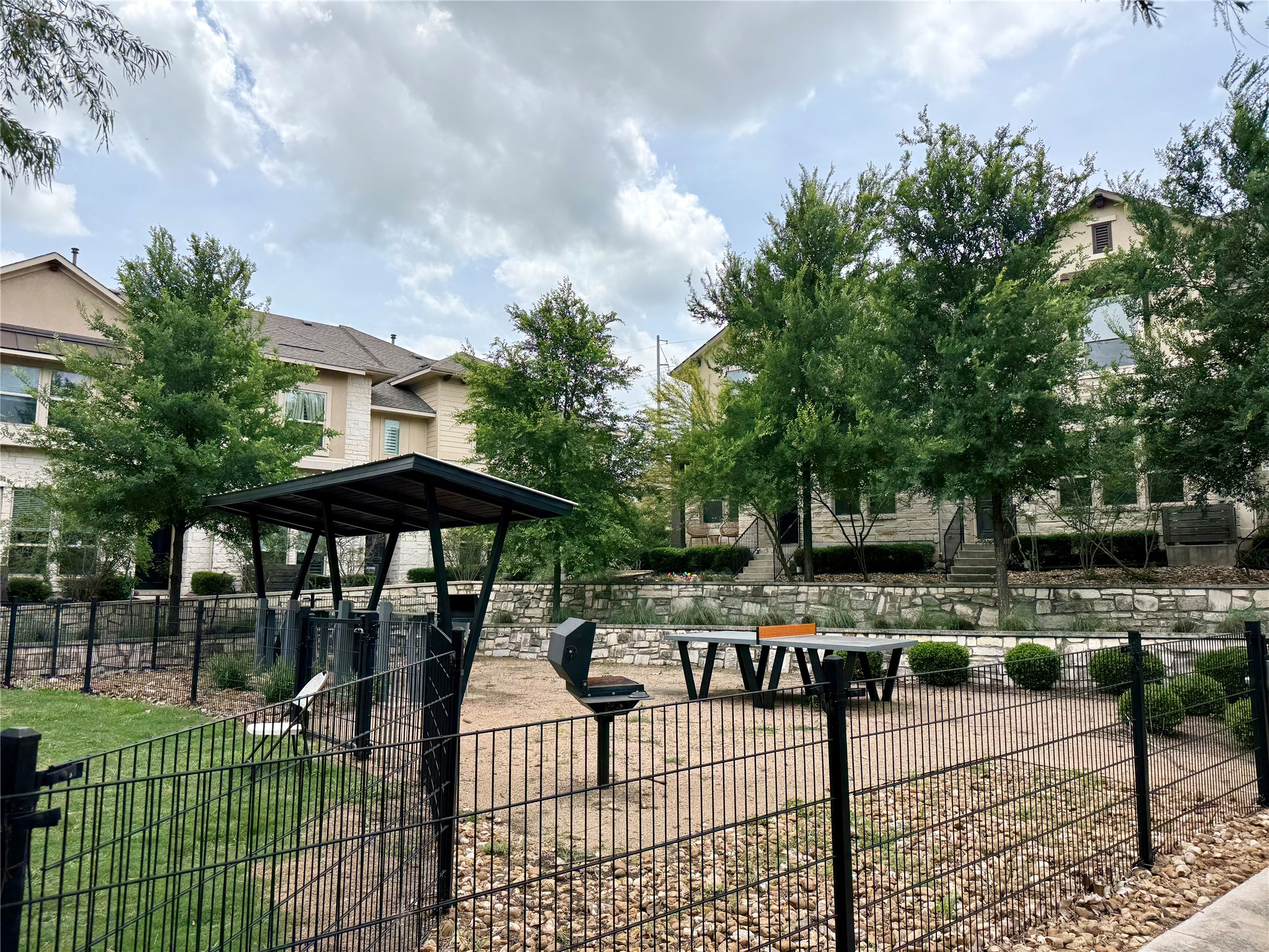 6814 East Riverside Drive, Unit 73 Austin, TX 78741 - Photo 32 of 33 Outdoor recreation space featuring a black metal fence, covered seating area, built-in BBQ grill, and a ping-pong table