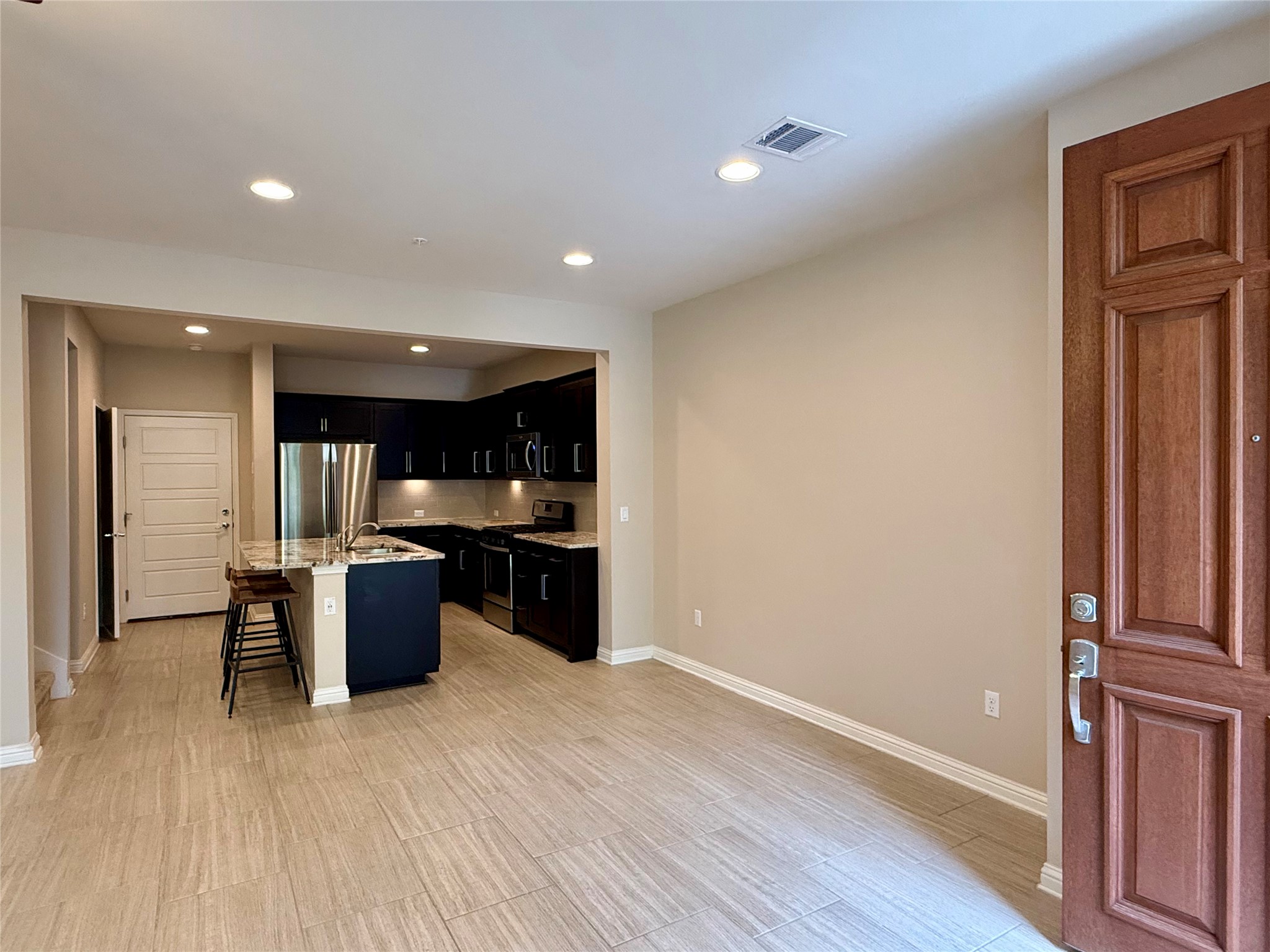 6814 East Riverside Drive, Unit 73 Austin, TX 78741 - Photo 5 of 33 Open-concept living area featuring wood-finish tile flooring, recessed lighting, and a modern kitchen