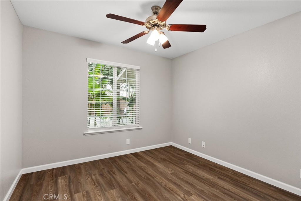 2159 Elm Street, Unit 2 Chico, CA 95928 - Photo 12 of 28 an empty room with wooden floor chandelier fan and windows