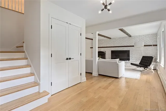 a bedroom with a bed a chair and a fireplace