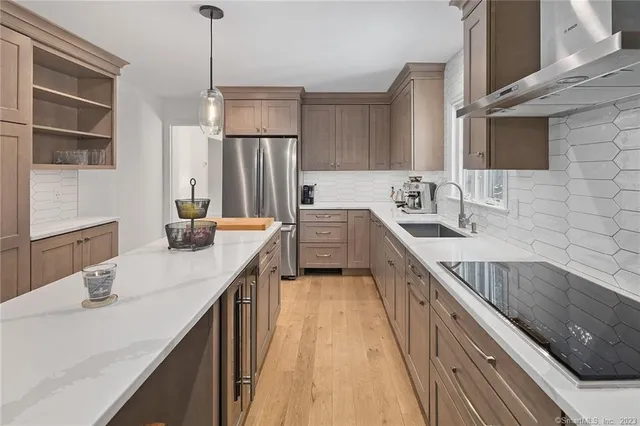 a kitchen with stainless steel appliances kitchen island granite countertop a stove a sink and a refrigerator