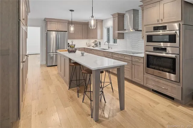 a kitchen with a dining table chairs and large windows