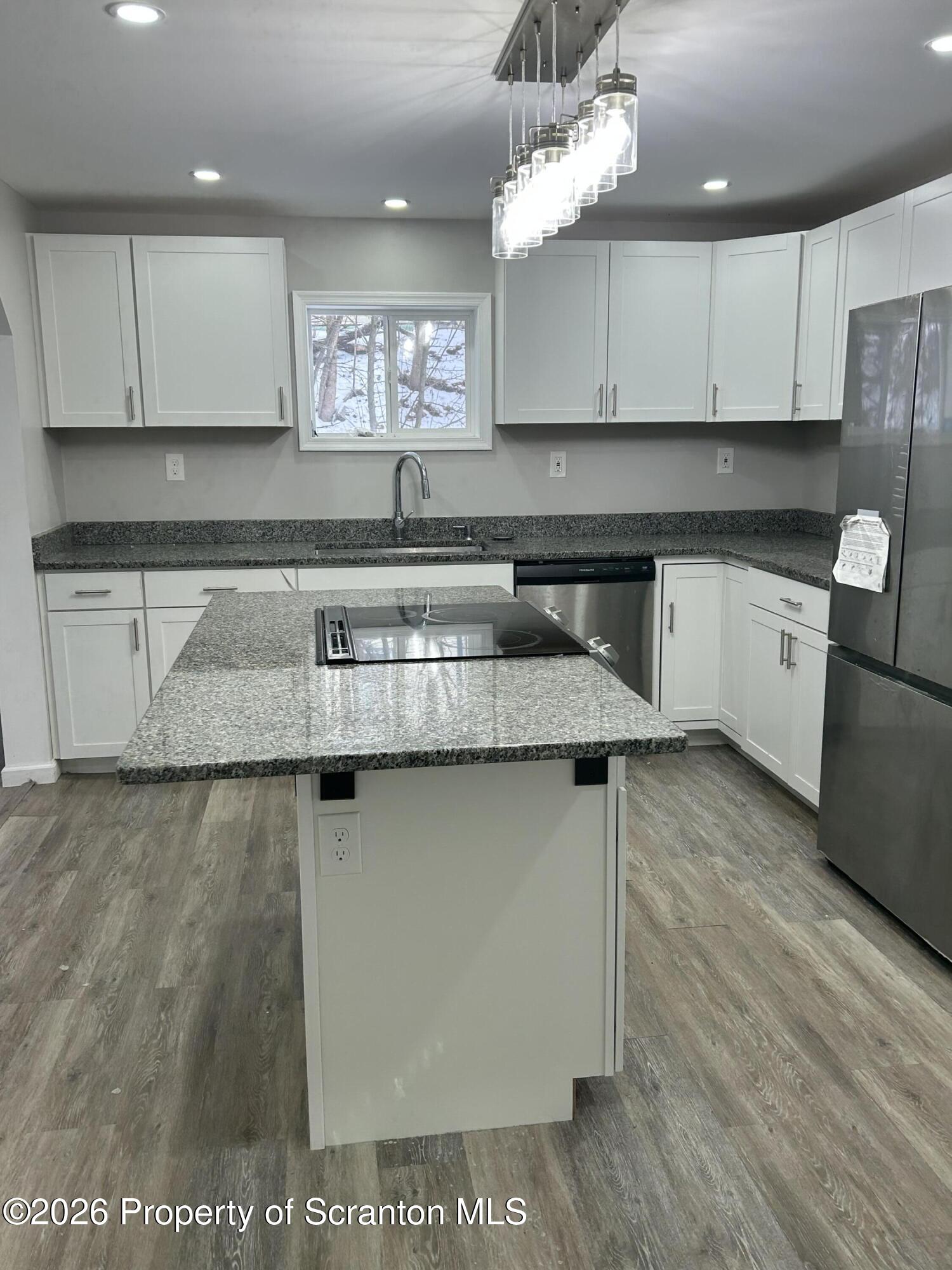 337 Wayne Street Archbald, PA 18403 - Photo 9 of 26 a kitchen with stainless steel appliances granite countertop a sink a stove a refrigerator cabinets and wooden floor