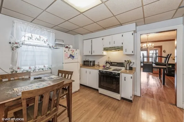 a kitchen with granite countertop white cabinets and stainless steel appliances