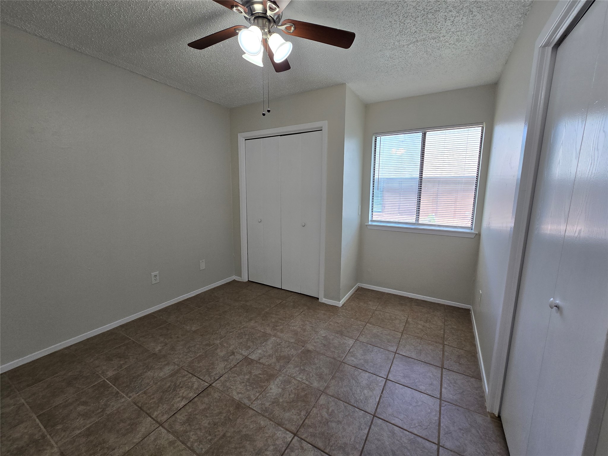 6206 Buffalo Pass, Unit A Austin, TX 78745 - Photo 15 of 24 Functional bedroom with tiled flooring and a convenient ceiling fan.