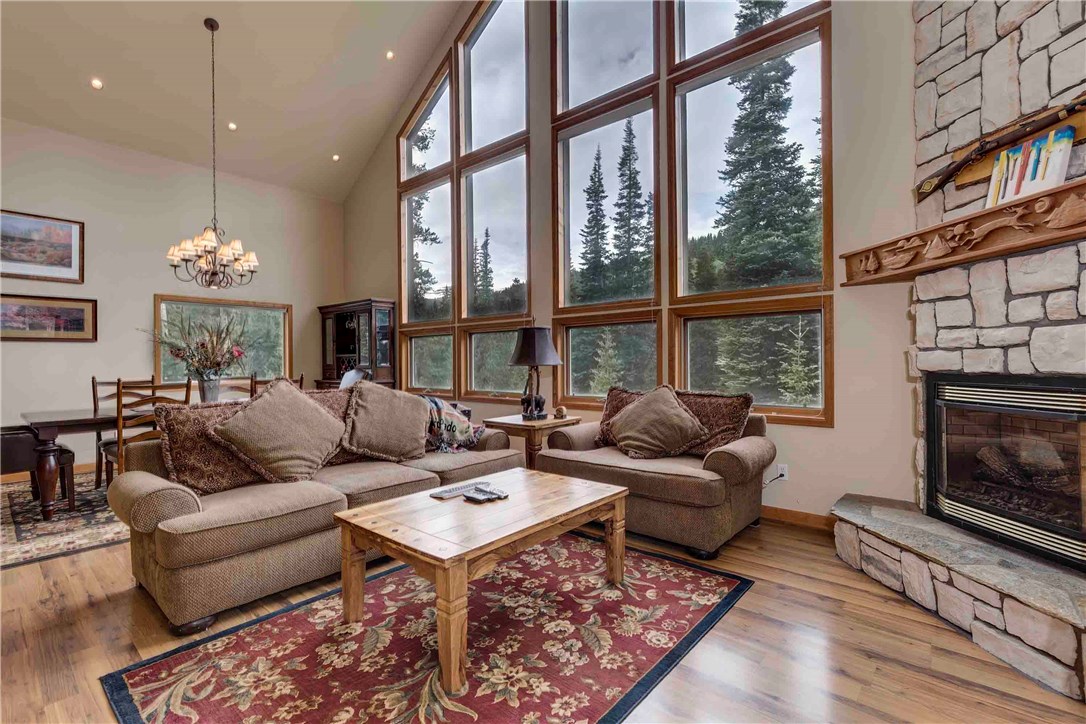 223 Range Road Breckenridge, CO 80424 - Photo 2 of 25 Open great room with floor to ceiling stone fireplace and wall of windows. Incredible natural light. View of Quandary!