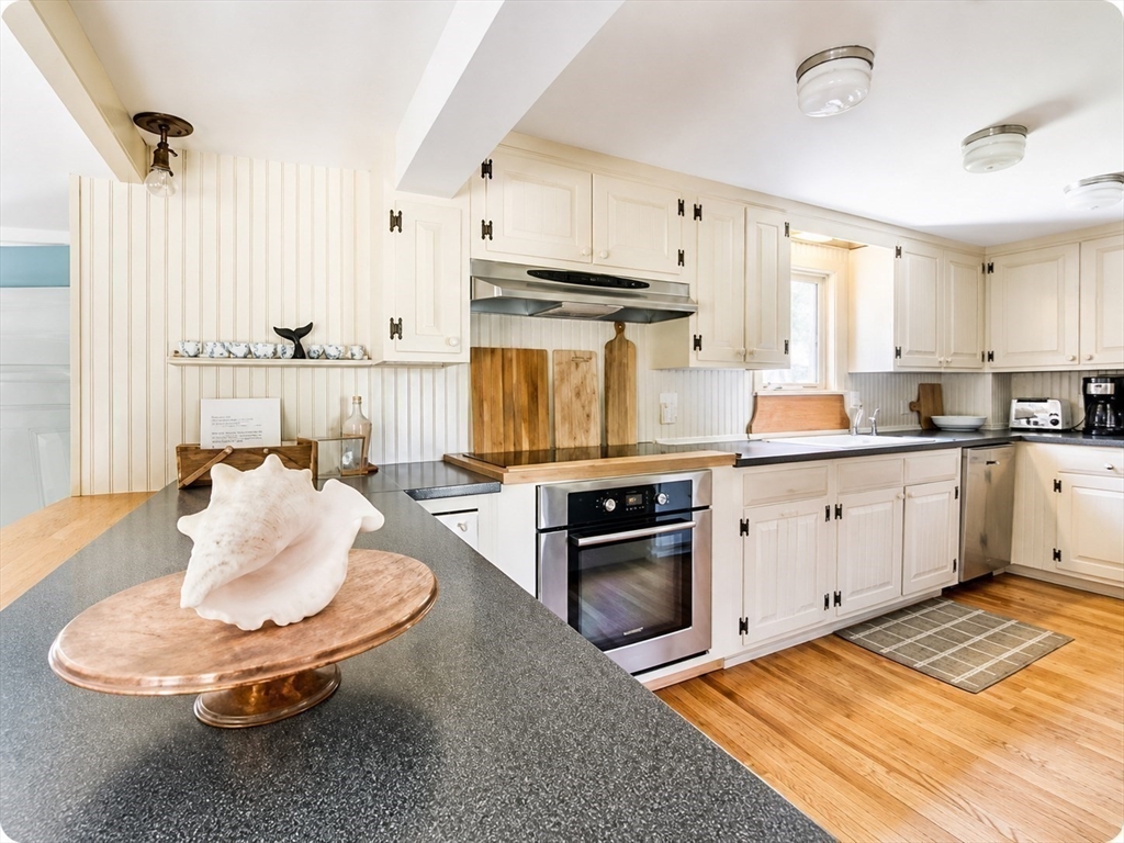 60 Rock Harbor Road Orleans, MA 02653 - Photo 10 of 37 a kitchen with kitchen island granite countertop a sink cabinets and stainless steel appliances