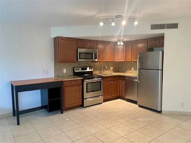 a metallic refrigerator freezer sitting in a kitchen