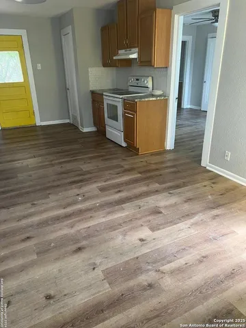 an empty room with wooden floor and a window