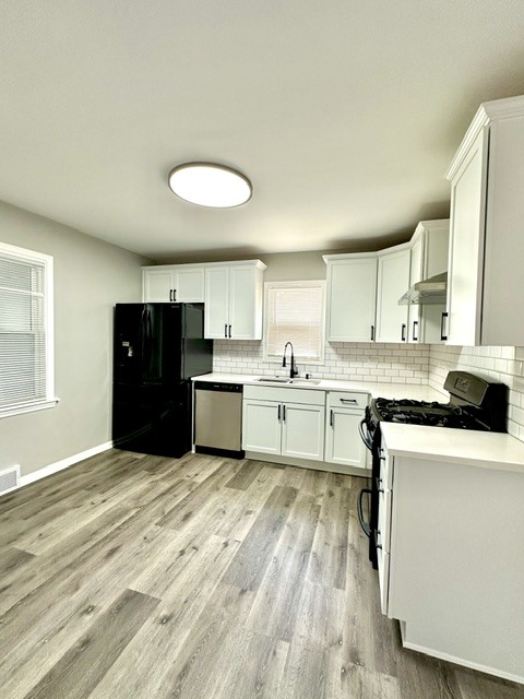 513 Cookane Avenue Elgin, IL 60120 - Photo 5 of 26 a kitchen with stainless steel appliances granite countertop a stove top oven a sink dishwasher and white cabinets with wooden floor