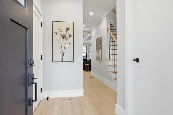 a view of a hallway with wooden floor and entryway