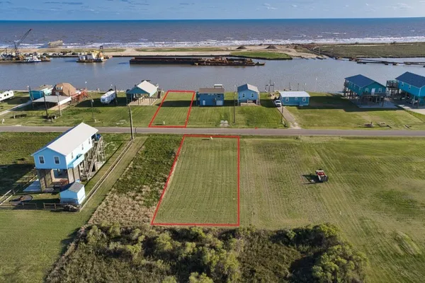 an aerial view of residential houses with outdoor space and lake view