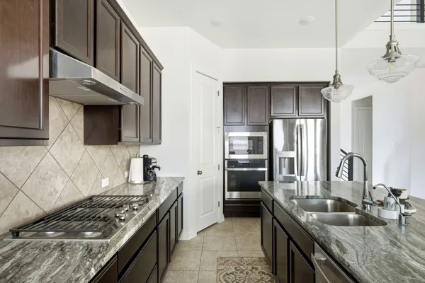 a kitchen with stainless steel appliances granite countertop a sink stove and refrigerator