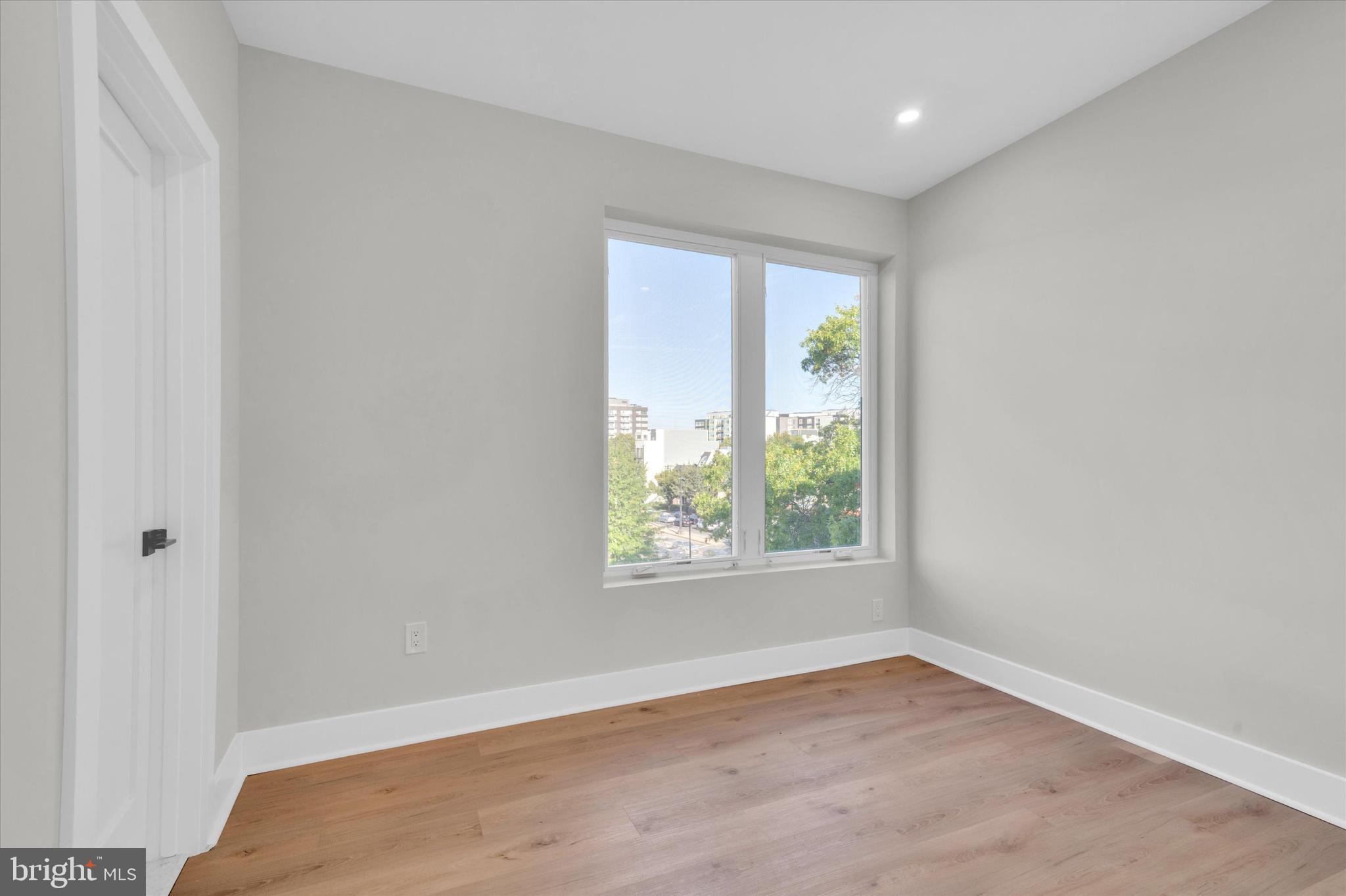 1915 Benning Road Northeast, Unit PH9 Washington, DC 20002 - Photo 14 of 20 an empty room with wooden floor and windows