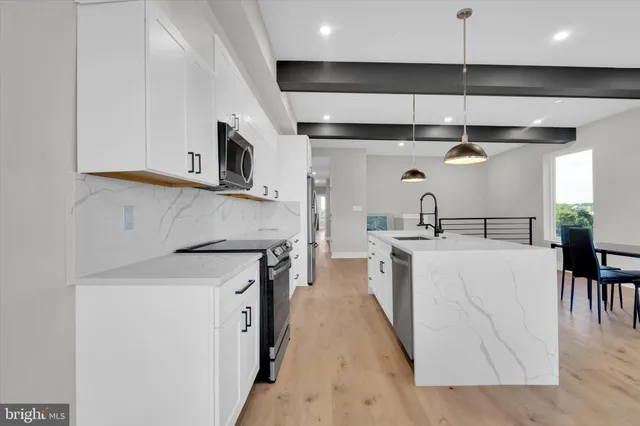 a kitchen with stainless steel appliances granite countertop a sink a stove and a refrigerator