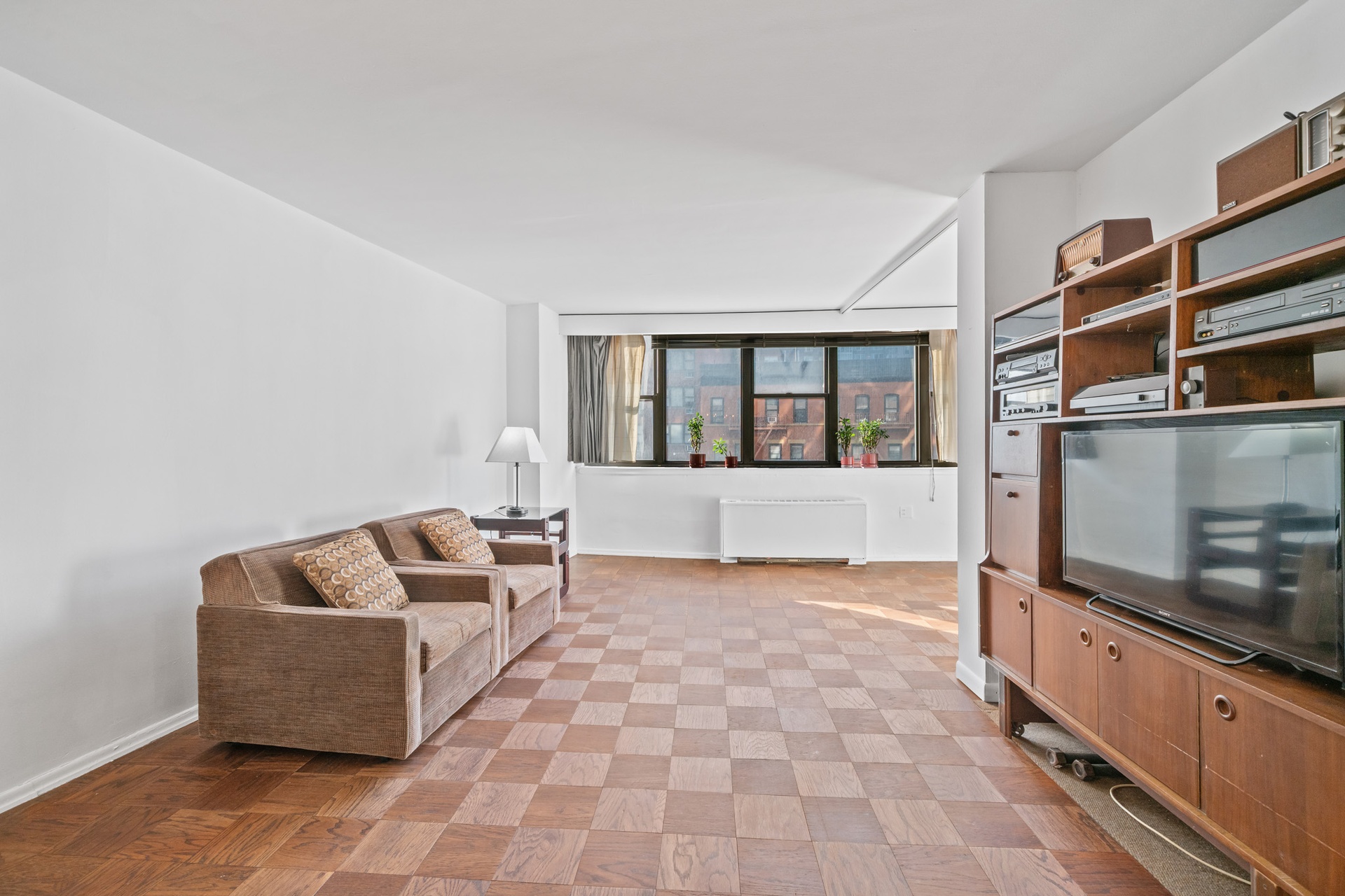 225 East 36th Street, Unit 5G Manhattan, NY 10016 - Photo 11 of 11 a living room with furniture and a flat screen tv