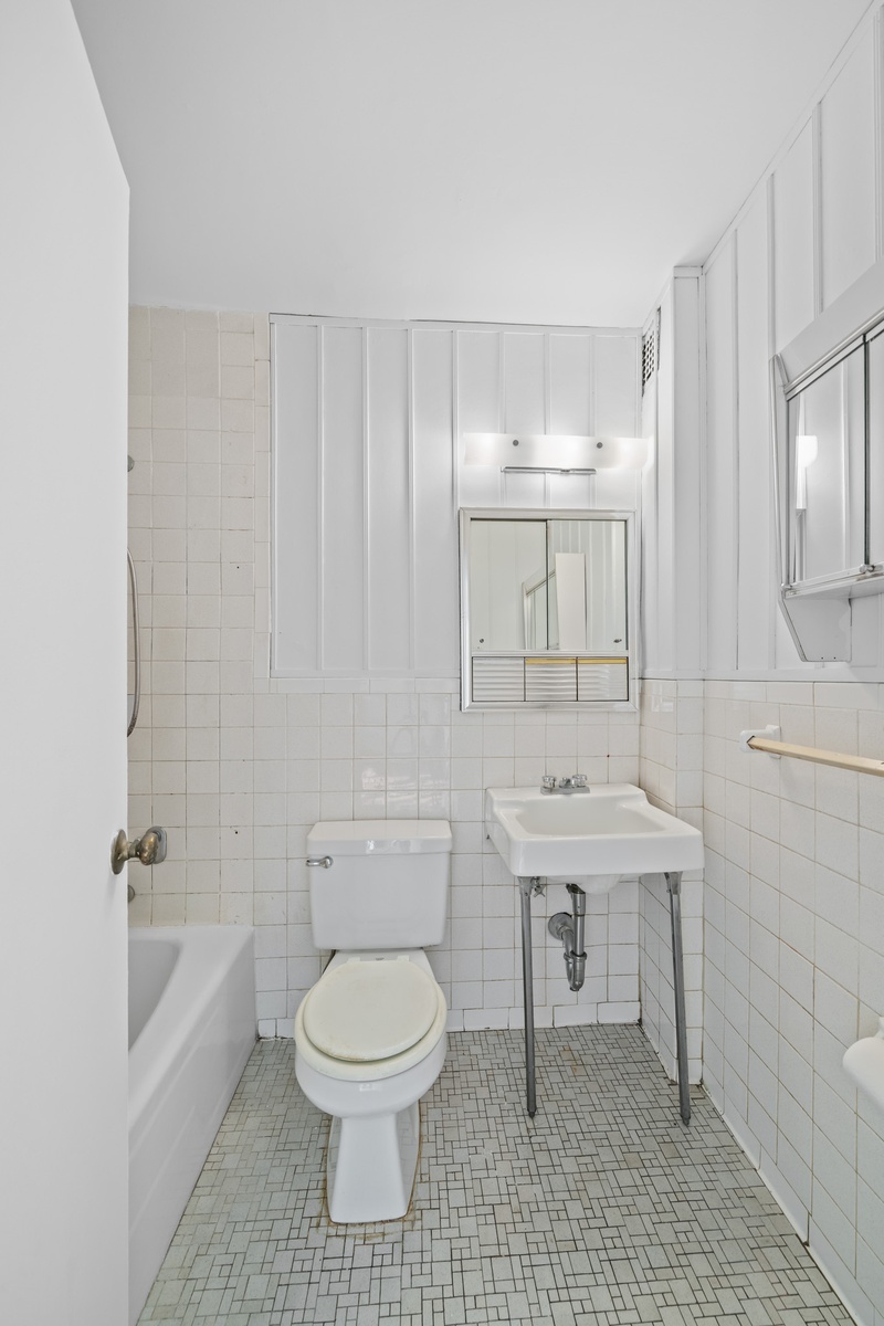 225 East 36th Street, Unit 5G Manhattan, NY 10016 - Photo 5 of 11 a bathroom with a toilet a sink a mirror and bathtub