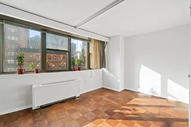 a large white bed in a room next to a window