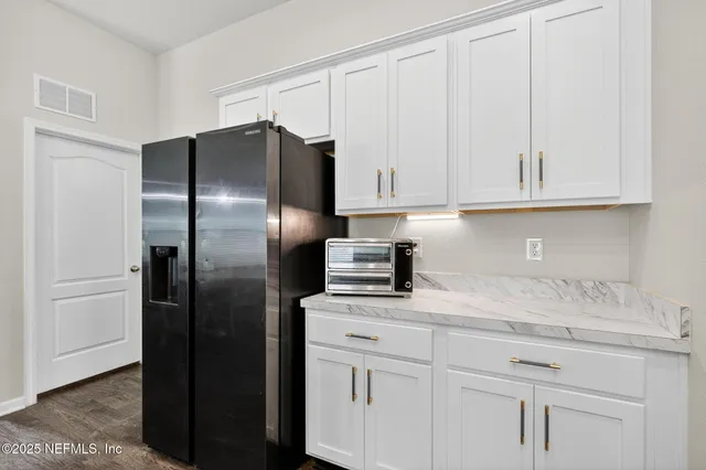 a view of a dining room with furniture a chandelier and wooden floor