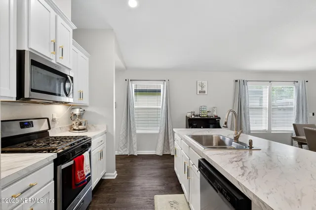 a living room with furniture a chandelier and a flat screen tv