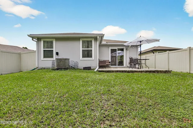a front view of a house with a garden and trees