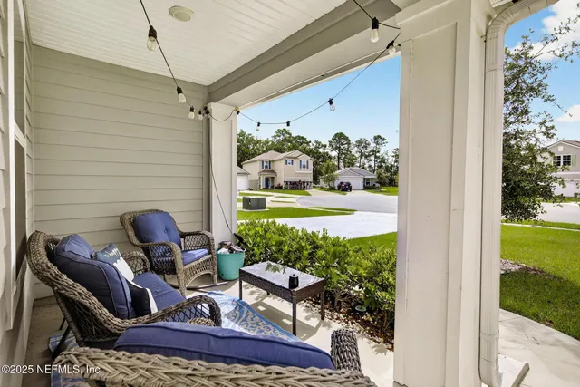 a view of a porch with furniture and a yard