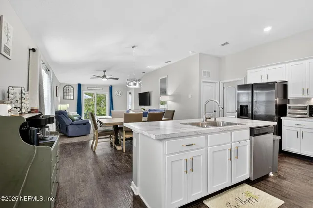 a kitchen with granite countertop a sink stove and refrigerator