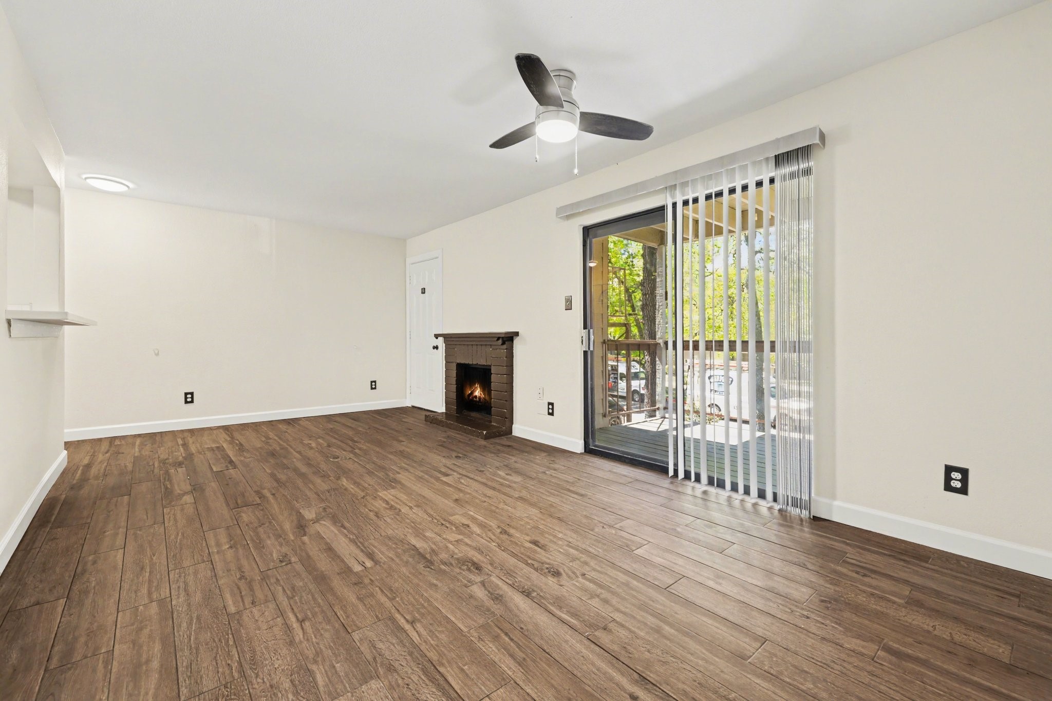 3500 Tangle Brush Drive, Unit 83 Spring, TX 77381 - Photo 5 of 17 Spacious living room with a cozy fireplace and access to the balcony.