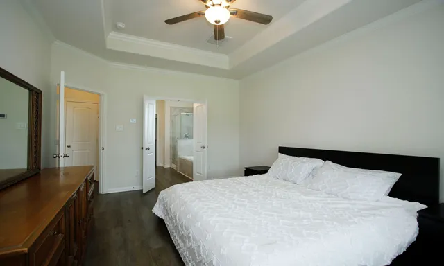a spacious bedroom with a bed and a chandelier