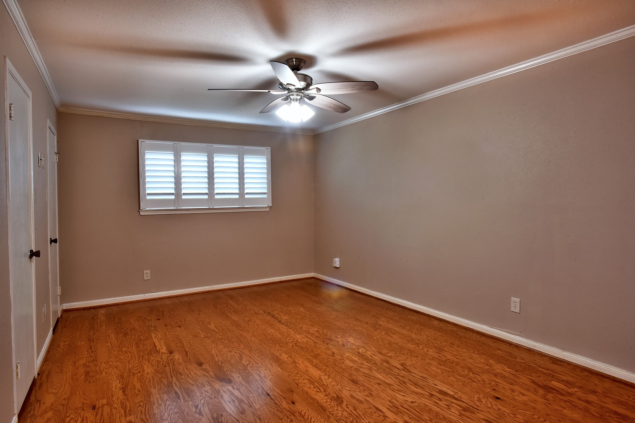 7441 Brompton Street Houston, TX 77025 - Photo 12 of 21 a view of an empty room with wooden floor and a chandelier fan