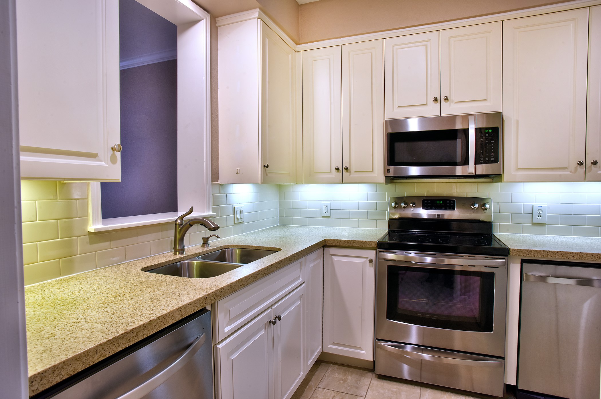 7441 Brompton Street Houston, TX 77025 - Photo 9 of 21 a kitchen with granite countertop a sink a stove and cabinets