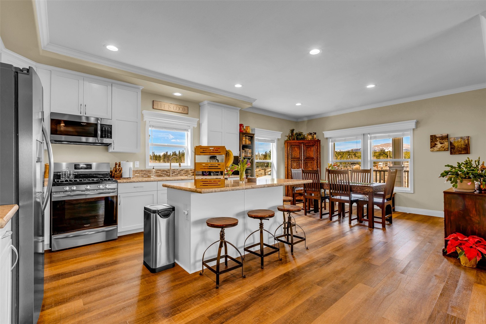 108 A Sun Rock Road, Unit A Fairplay, CO 80440 - Photo 2 of 48 a kitchen with stainless steel appliances granite countertop a stove top oven a sink a dining table and chairs with wooden floor