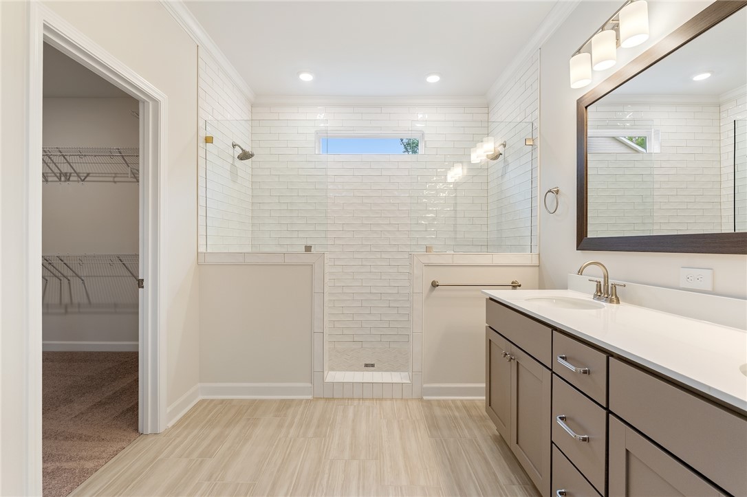 110 Lakeside Drive Anderson, SC 29621 - Photo 20 of 34 This spacious bathroom offers a double vanity and a glass-enclosed shower with tile finishes.