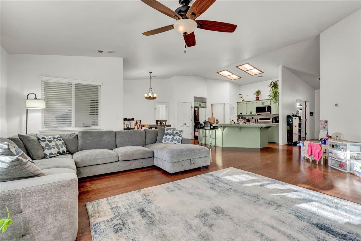 695 Crescent Lane Lemoore, CA 93245 - Photo 19 of 51 a living room with furniture kitchen view and a wooden floor