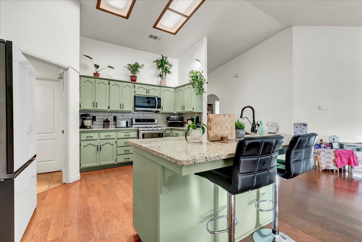 695 Crescent Lane Lemoore, CA 93245 - Photo 27 of 51 a kitchen with stainless steel appliances kitchen island granite countertop a sink and cabinets