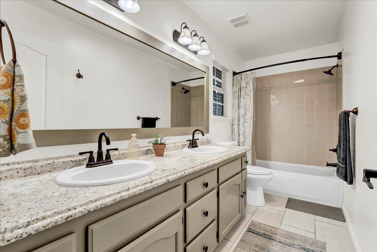 695 Crescent Lane Lemoore, CA 93245 - Photo 29 of 51 a bathroom with a granite countertop sink a toilet a mirror and shower