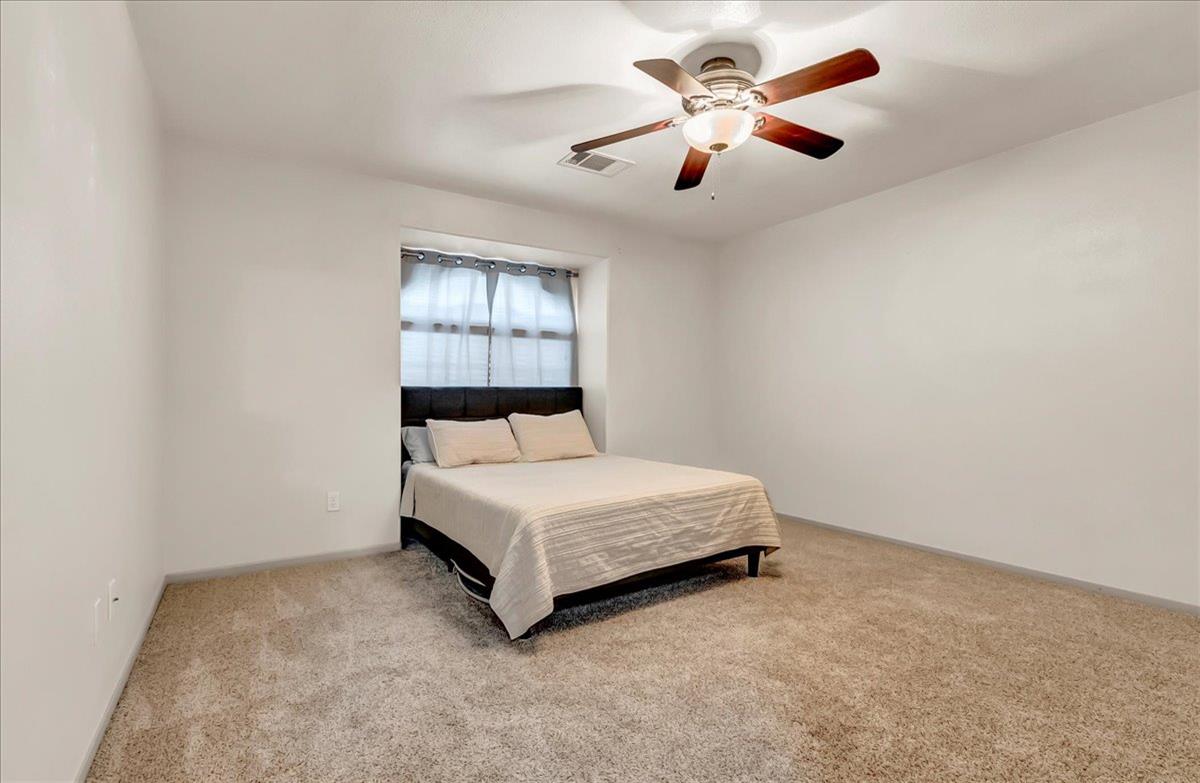 695 Crescent Lane Lemoore, CA 93245 - Photo 30 of 51 a room with a bed and a ceiling fan in it