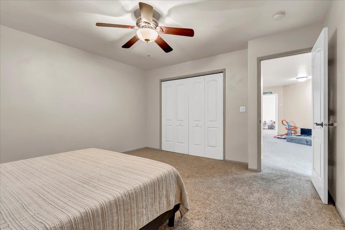 695 Crescent Lane Lemoore, CA 93245 - Photo 31 of 51 a spacious bedroom with a bed and a chandelier