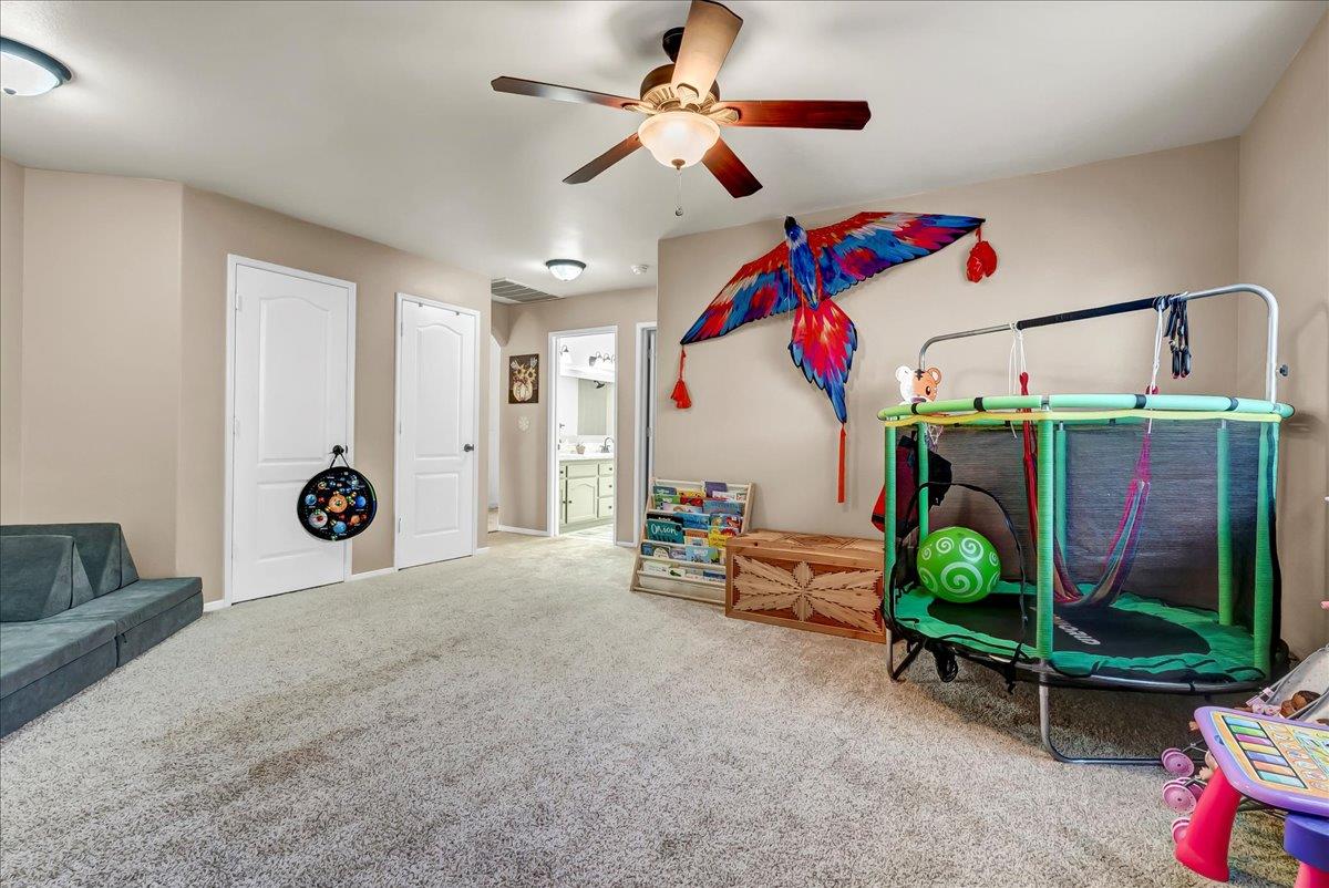 695 Crescent Lane Lemoore, CA 93245 - Photo 33 of 51 a bedroom with a bed and a chandelier