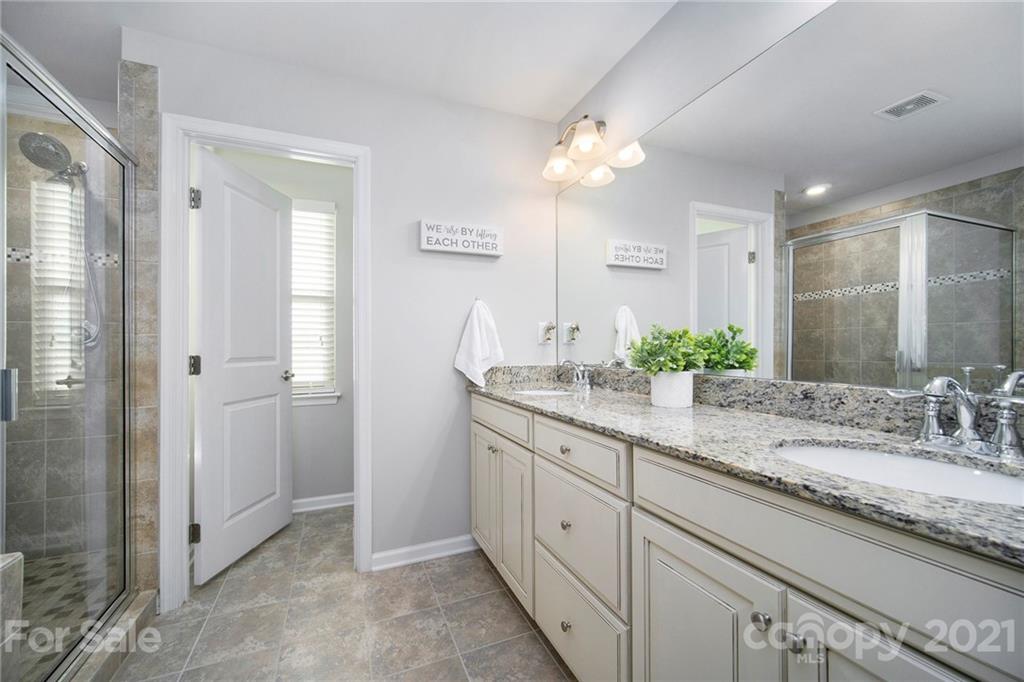 2159 Stone Pile Drive Concord, NC 28025 - Photo 22 of 33 a bathroom with a granite countertop double vanity sink mirror and shower