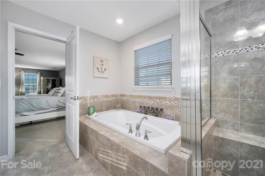 2159 Stone Pile Drive Concord, NC 28025 - Photo 23 of 33 a bathroom with a tub a sink and a window