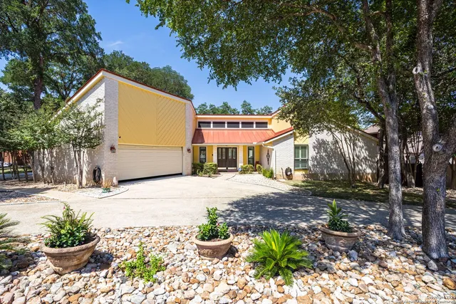 a front view of a house with a yard and a garden