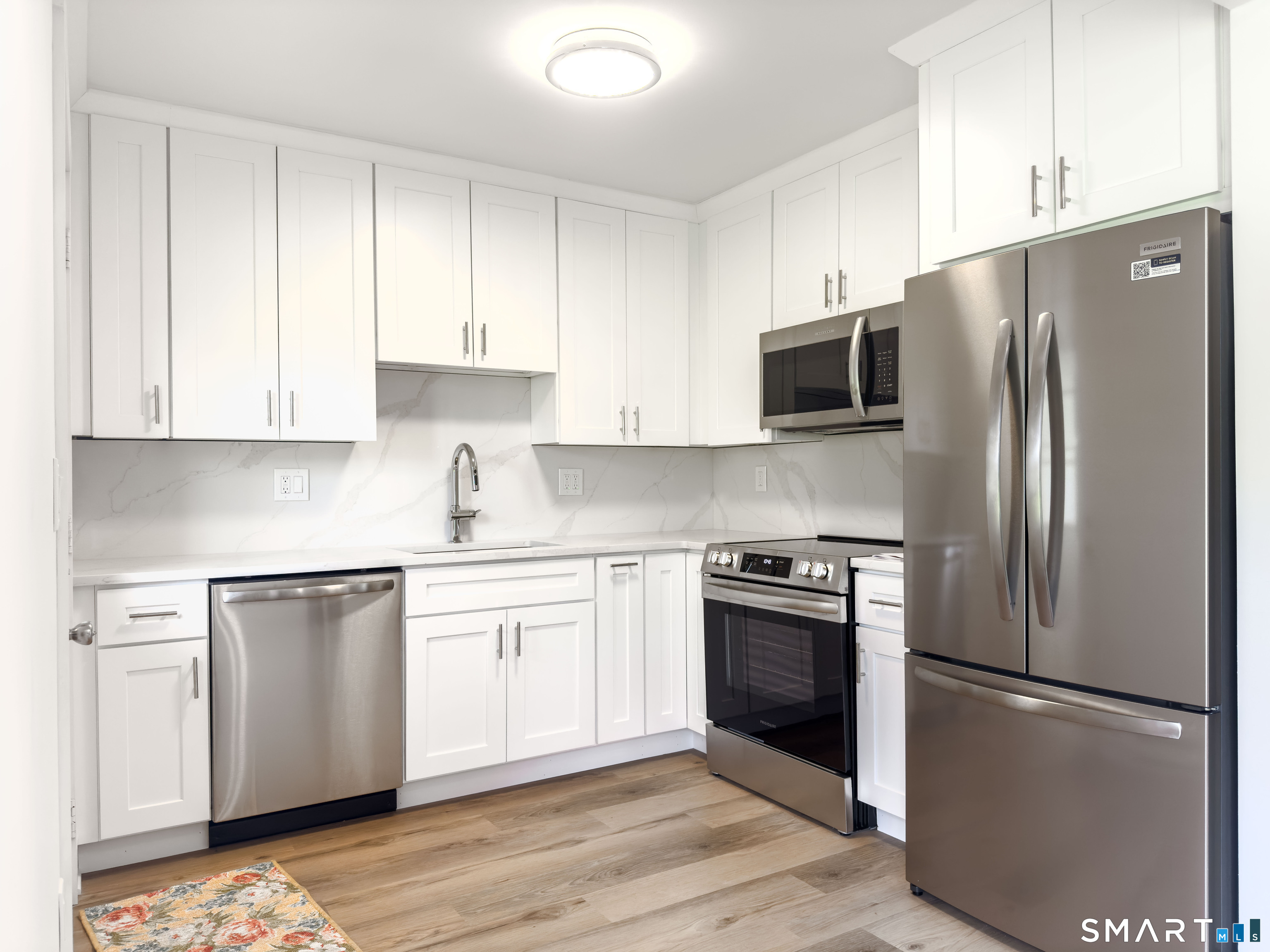 63 Glen Ridge Court, Unit 63 New Milford, CT 06776 - Photo 3 of 15 a kitchen with stainless steel appliances granite countertop a refrigerator stove a sink and dishwasher with wooden floor